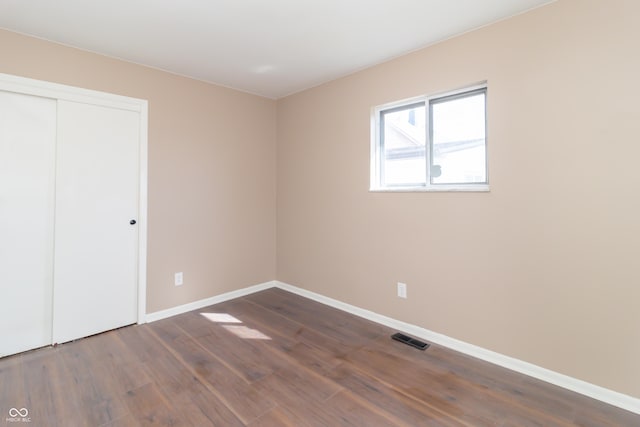 1701 Nelson Ave, Indianapolis, IN 46203 - unfurnished bedroom featuring dark wood finished floors, visible vents, a closet, and baseboards