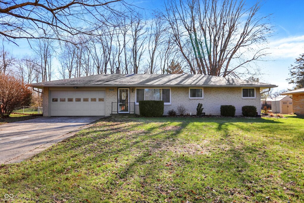 7133 Mc Lain Dr, Indianapolis, IN 46217 - single story home featuring a front yard, concrete driveway, brick siding, and a garage
