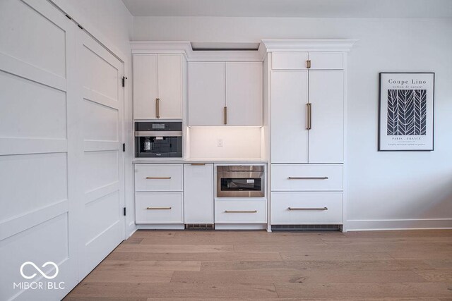 395 Breakwater Dr, Fishers, IN 46037 - kitchen with white cabinets, light countertops, oven, baseboards, and light wood-style floors