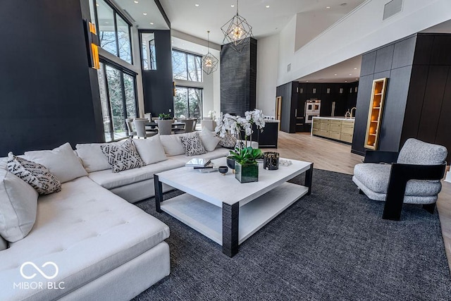 395 Breakwater Dr, Fishers, IN 46037 - living room with light wood-style flooring, a towering ceiling, recessed lighting, and a chandelier