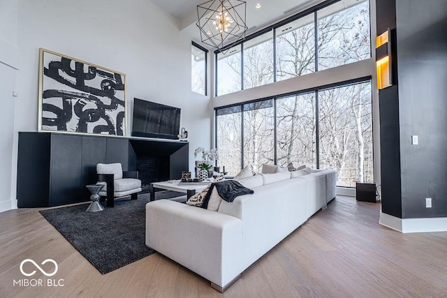 395 Breakwater Dr, Fishers, IN 46037 - living area featuring a high ceiling, baseboards, wood finished floors, and an inviting chandelier