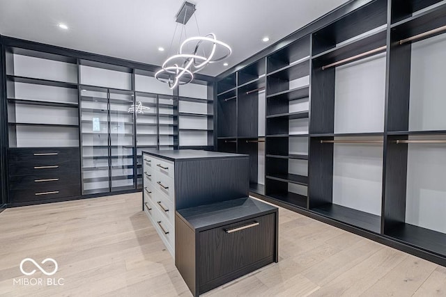 395 Breakwater Dr, Fishers, IN 46037 - walk in closet featuring light wood-type flooring and a notable chandelier