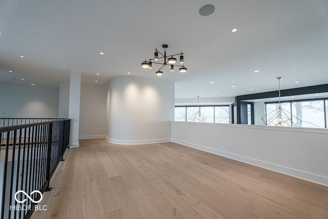 395 Breakwater Dr, Fishers, IN 46037 - empty room with baseboards, light wood-type flooring, recessed lighting, and a notable chandelier