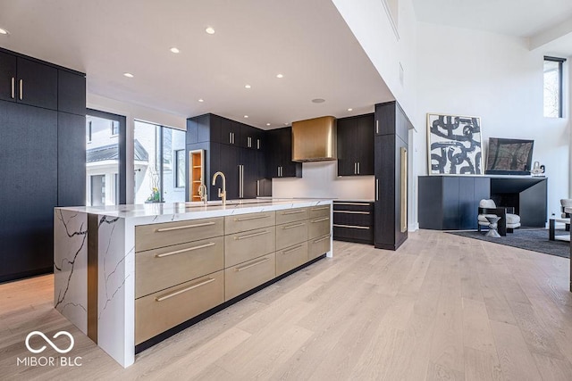 395 Breakwater Dr, Fishers, IN 46037 - kitchen with recessed lighting, a sink, light wood-style flooring, modern cabinets, and wall chimney exhaust hood