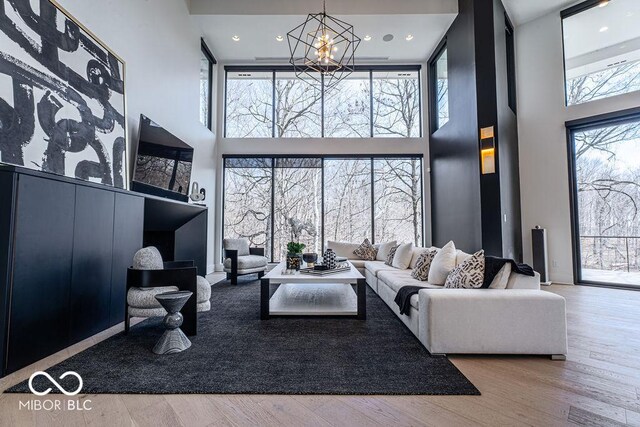 395 Breakwater Dr, Fishers, IN 46037 - living room featuring a high ceiling, wood finished floors, and a chandelier