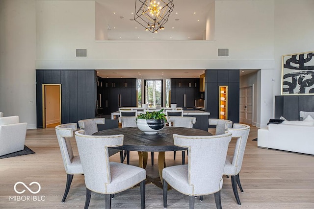 395 Breakwater Dr, Fishers, IN 46037 - dining room with light wood finished floors, visible vents, a towering ceiling, and an inviting chandelier