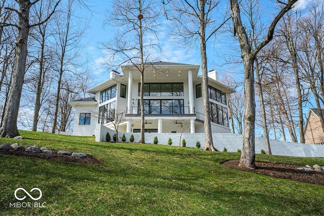 395 Breakwater Dr, Fishers, IN 46037 - view of front of property featuring stucco siding, a balcony, a front lawn, a ceiling fan, and a chimney