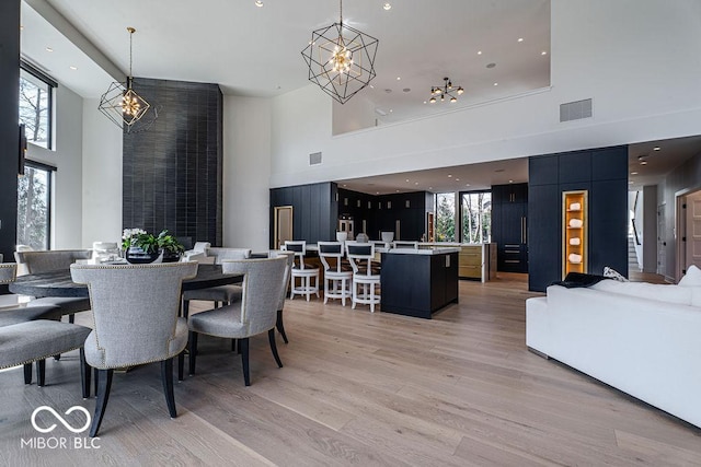 395 Breakwater Dr, Fishers, IN 46037 - dining area with a high ceiling, light wood-style floors, a chandelier, and visible vents