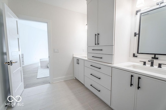 395 Breakwater Dr, Fishers, IN 46037 - bathroom featuring baseboards, double vanity, and a sink