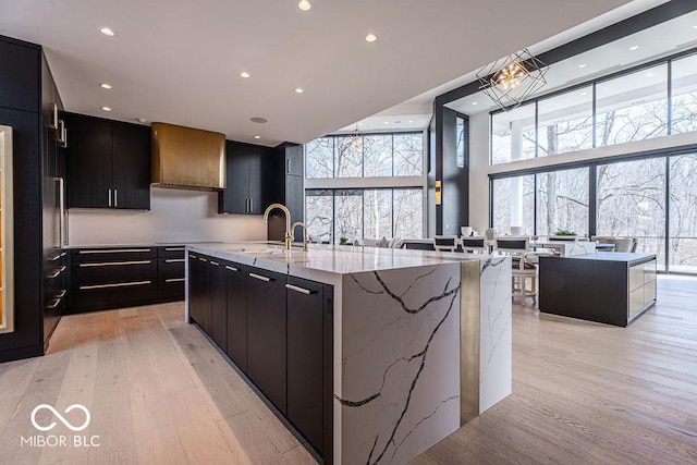 395 Breakwater Dr, Fishers, IN 46037 - kitchen with a spacious island, a sink, light wood finished floors, modern cabinets, and dark cabinets