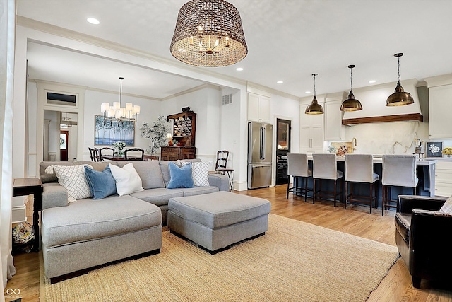 450 W Ash St, Zionsville, IN 46077 - living area featuring ornamental molding, light wood finished floors, a chandelier, and recessed lighting