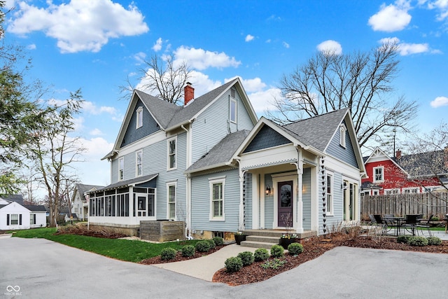 450 W Ash St, Zionsville, IN 46077 - view of front facade with central AC, a shingled roof, a sunroom, a chimney, and fence