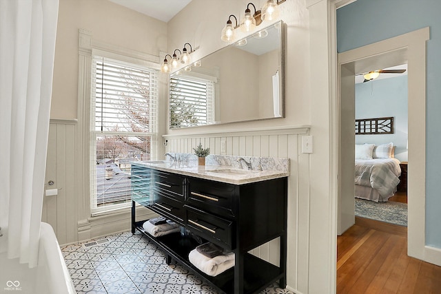 450 W Ash St, Zionsville, IN 46077 - ensuite bathroom featuring double vanity, ensuite bath, wainscoting, ceiling fan, and a sink