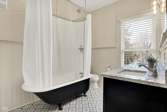 450 W Ash St, Zionsville, IN 46077 - bathroom with toilet, shower / bathtub combination with curtain, vanity, and a wainscoted wall
