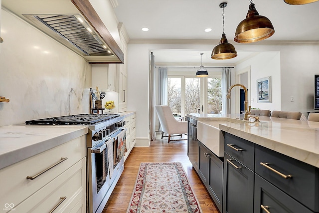 450 W Ash St, Zionsville, IN 46077 - kitchen featuring pendant lighting, exhaust hood, ornamental molding, a sink, and gas range oven