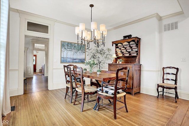 450 W Ash St, Zionsville, IN 46077 - dining space with baseboards, ornamental molding, a chandelier, visible vents, and light wood finished floors