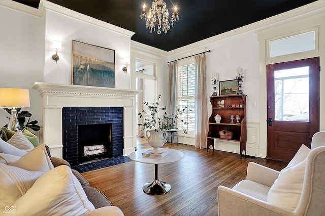 450 W Ash St, Zionsville, IN 46077 - living room with a notable chandelier, wood-type flooring, a brick fireplace, and crown molding
