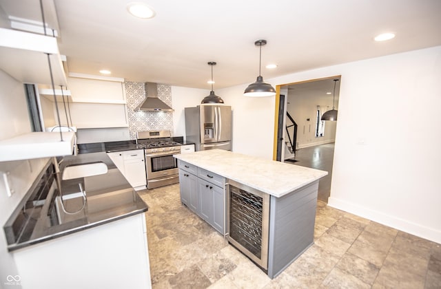 kitchen featuring tasteful backsplash, stainless steel appliances, wine cooler, a sink, and wall chimney range hood