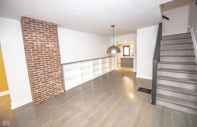 interior space with stairs, visible vents, wood finished floors, and baseboards