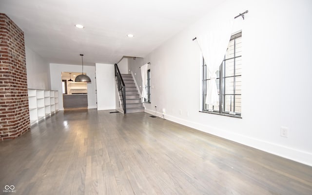 unfurnished living room with stairway, recessed lighting, baseboards, visible vents, and wood finished floors