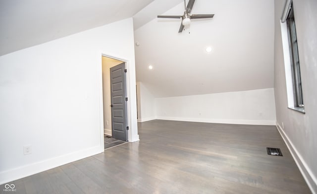 bonus room featuring dark wood-style flooring, visible vents, baseboards, a ceiling fan, and vaulted ceiling
