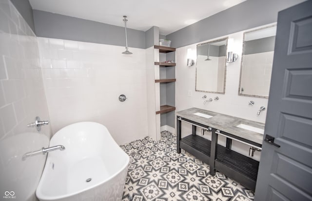 bathroom with double vanity, a sink, a freestanding tub, and tiled shower