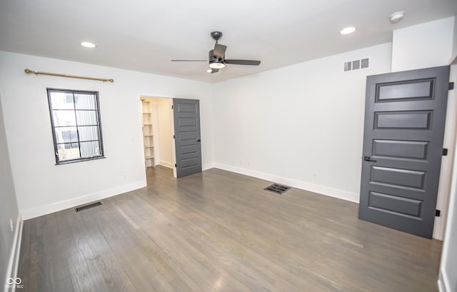 unfurnished room featuring baseboards, ceiling fan, visible vents, and dark wood finished floors