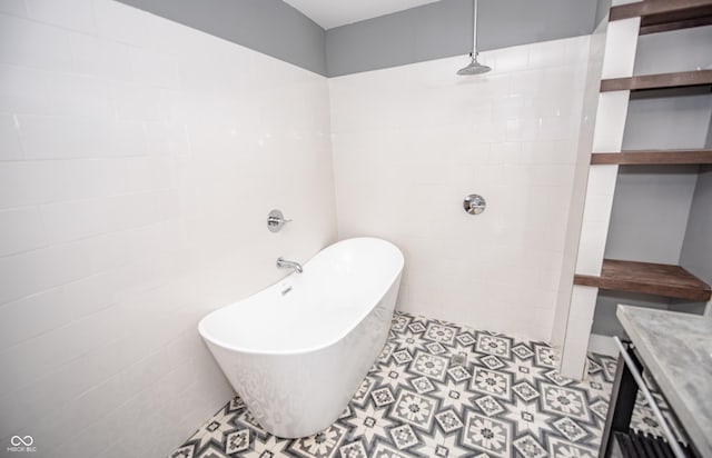 full bath with a freestanding tub, a tile shower, tile patterned flooring, and tile walls