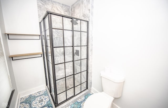 full bathroom featuring a stall shower, baseboards, and toilet