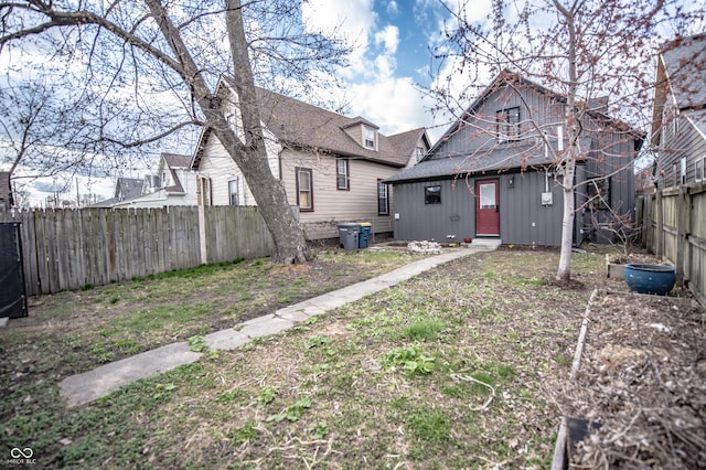 rear view of house featuring a fenced backyard