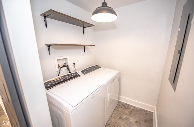 clothes washing area with washing machine and clothes dryer, baseboards, and laundry area