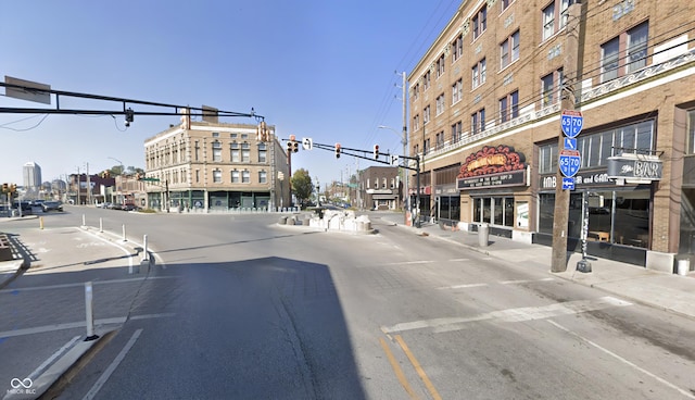 view of street featuring curbs, traffic signs, street lights, and sidewalks