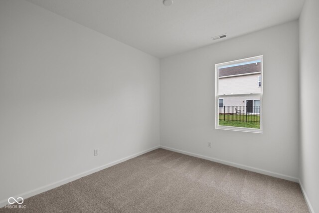unfurnished room with carpet and baseboards