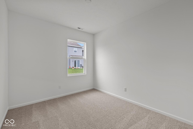 carpeted empty room featuring baseboards