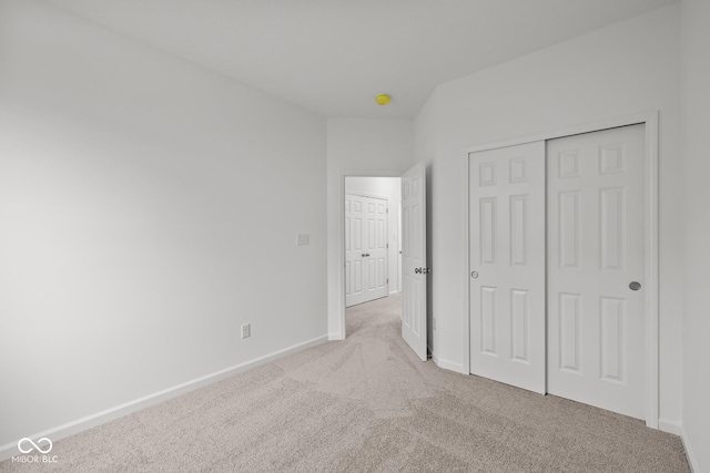 unfurnished bedroom with carpet floors, baseboards, and a closet