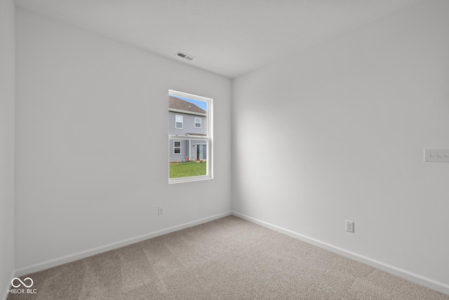 carpeted spare room featuring baseboards