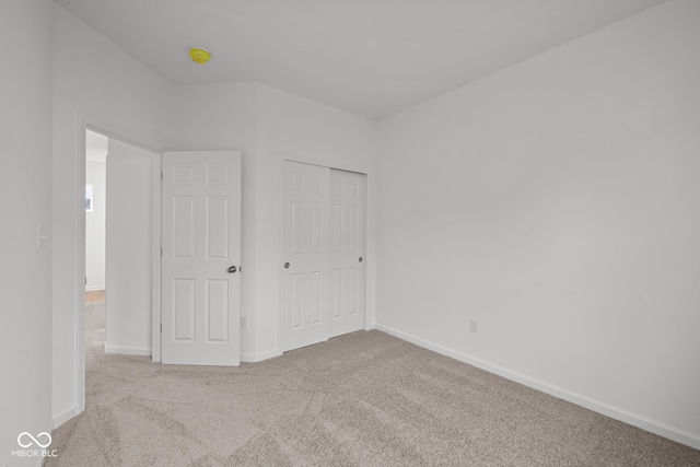 unfurnished bedroom featuring carpet, baseboards, and a closet