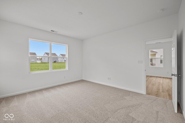 empty room with light carpet and baseboards