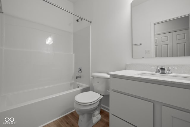 full bathroom with wood finished floors, toilet, vanity, and washtub / shower combination