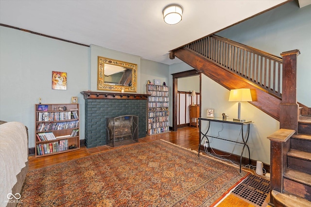 961 Woodruff Place W Dr, Indianapolis, IN 46201 - living room with stairs, wood finished floors, baseboards, and a brick fireplace