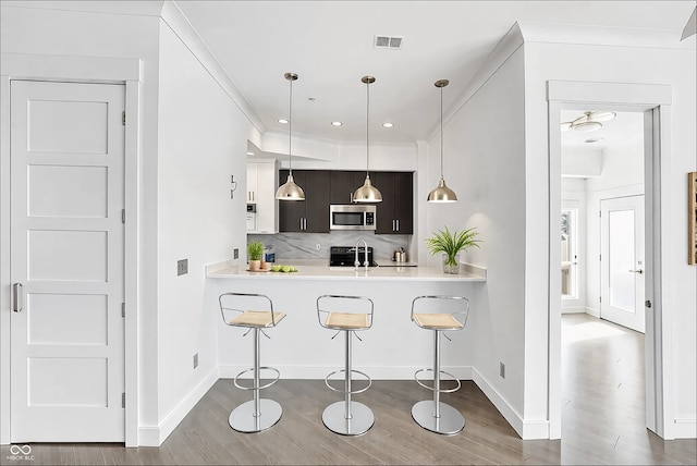 932 Broadway St # 15, Indianapolis, IN 46202 - kitchen featuring visible vents, decorative backsplash, light countertops, stove, and stainless steel microwave