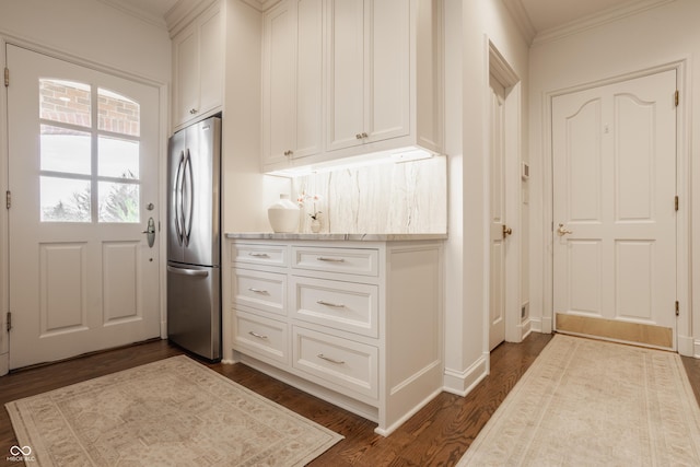foyer featuring ornamental molding, dark wood-type flooring, and baseboards