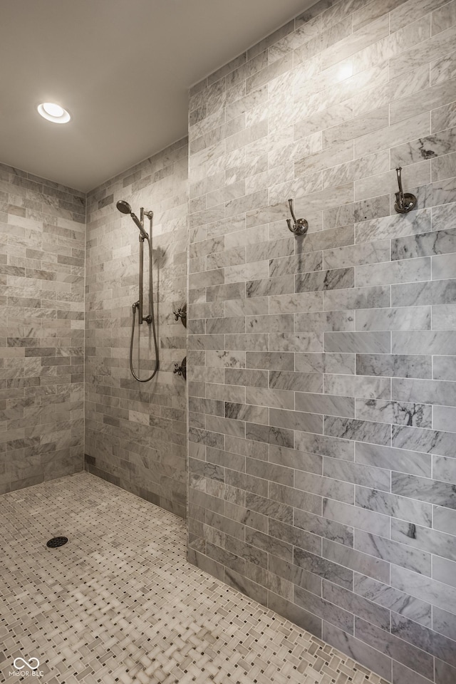 bathroom with a tile shower and recessed lighting