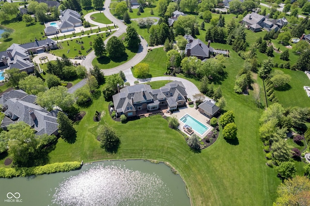 aerial view of property and surrounding area featuring a large body of water, nearby suburban area, and a pool
