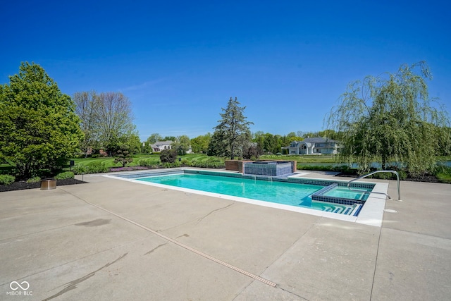 view of pool featuring a pool with connected hot tub and a patio area