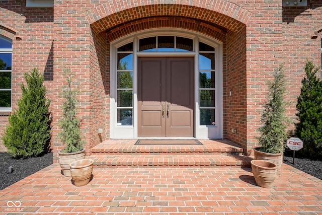 view of exterior entry featuring brick siding