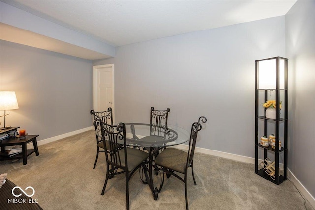 dining area with light carpet and baseboards
