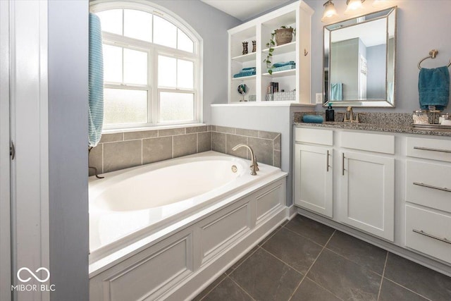 full bathroom featuring tile patterned floors, a garden tub, and vanity