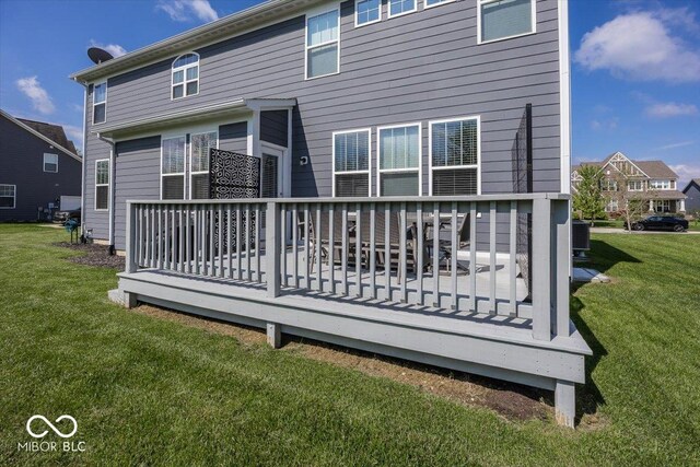 back of house with a wooden deck and a lawn