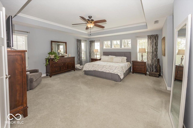 bedroom with a raised ceiling, carpet, baseboards, crown molding, and a ceiling fan
